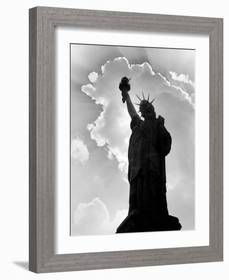 1960s Silhouette of Statue of Liberty with Sun Ray Clouds Behind-null-Framed Photographic Print