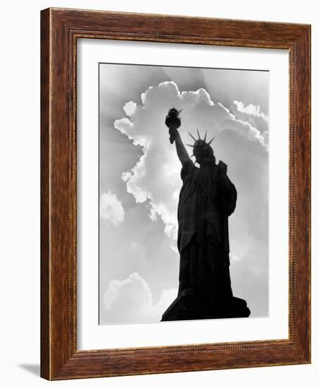 1960s Silhouette of Statue of Liberty with Sun Ray Clouds Behind-null-Framed Photographic Print