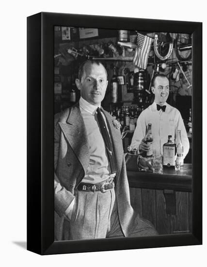 21 Club's Jack Kriendler Relaxing at Bar with Drink, Bartender Holding Bottle on Other Side of Bar-Eric Schaal-Framed Premier Image Canvas
