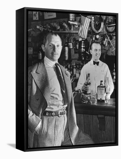 21 Club's Jack Kriendler Relaxing at Bar with Drink, Bartender Holding Bottle on Other Side of Bar-Eric Schaal-Framed Premier Image Canvas