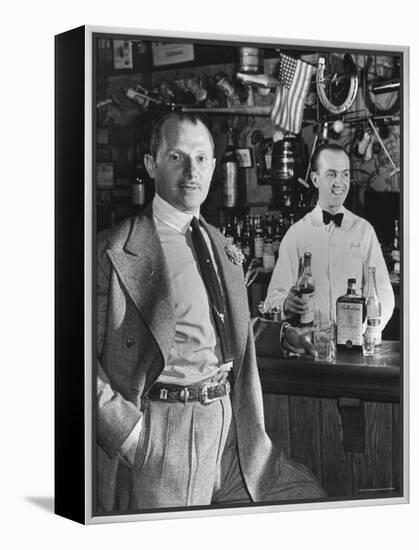 21 Club's Jack Kriendler Relaxing at Bar with Drink, Bartender Holding Bottle on Other Side of Bar-Eric Schaal-Framed Premier Image Canvas