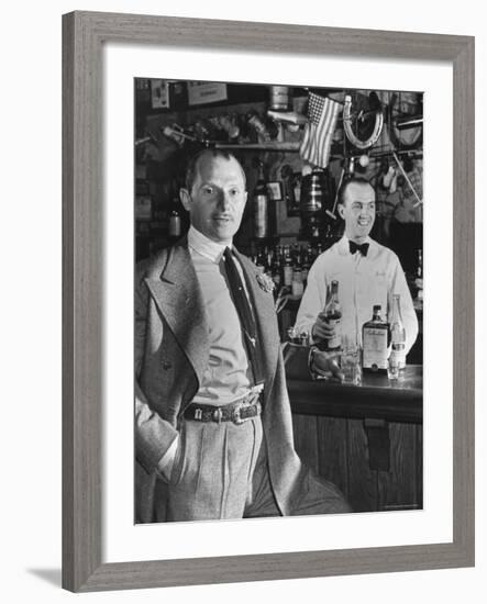 21 Club's Jack Kriendler Relaxing at Bar with Drink, Bartender Holding Bottle on Other Side of Bar-Eric Schaal-Framed Premium Photographic Print