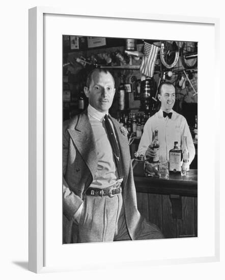 21 Club's Jack Kriendler Relaxing at Bar with Drink, Bartender Holding Bottle on Other Side of Bar-Eric Schaal-Framed Premium Photographic Print