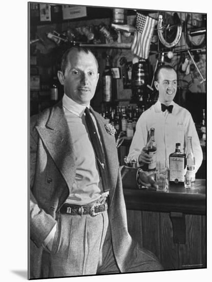 21 Club's Jack Kriendler Relaxing at Bar with Drink, Bartender Holding Bottle on Other Side of Bar-Eric Schaal-Mounted Premium Photographic Print