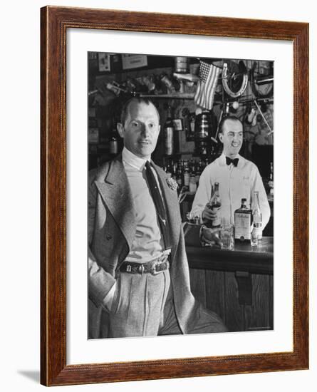 21 Club's Jack Kriendler Relaxing at Bar with Drink, Bartender Holding Bottle on Other Side of Bar-Eric Schaal-Framed Premium Photographic Print