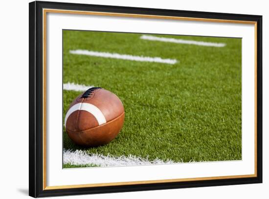 A American Football on a Green Football Field-flippo-Framed Photographic Print