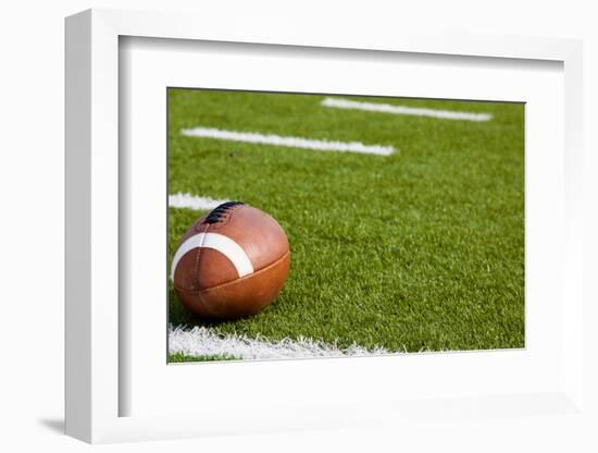 A American Football on a Green Football Field-flippo-Framed Photographic Print