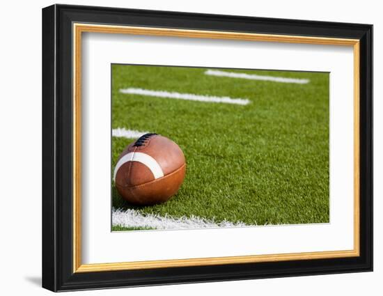 A American Football on a Green Football Field-flippo-Framed Photographic Print