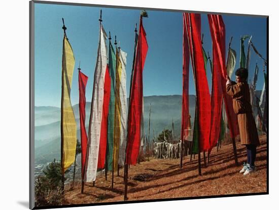A Bhutanese Man Straightens a Prayer Flag at a Buddhist Shrine-null-Mounted Photographic Print