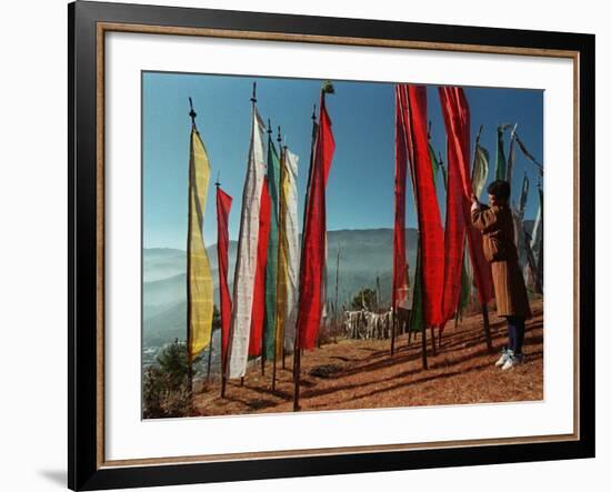 A Bhutanese Man Straightens a Prayer Flag at a Buddhist Shrine-null-Framed Photographic Print
