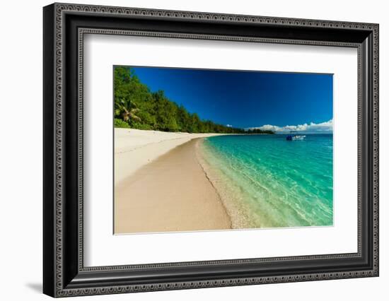 A boat anchored off the shore of a pristine tropical beach. Denis Island, Seychelles.-Sergio Pitamitz-Framed Photographic Print