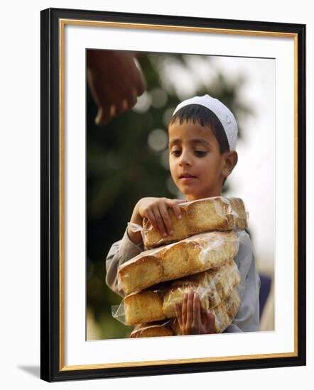 A Boy Carries Rusk as He Assists Others to Send a Consignment of Relief Supplies to Uri-null-Framed Photographic Print