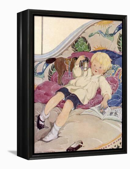A Boy Lying on a Bed with a Book and a Toy Horse-Anne Anderson-Framed Stretched Canvas