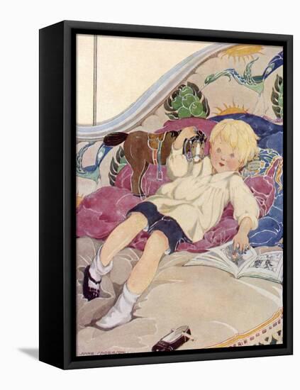 A Boy Lying on a Bed with a Book and a Toy Horse-Anne Anderson-Framed Stretched Canvas