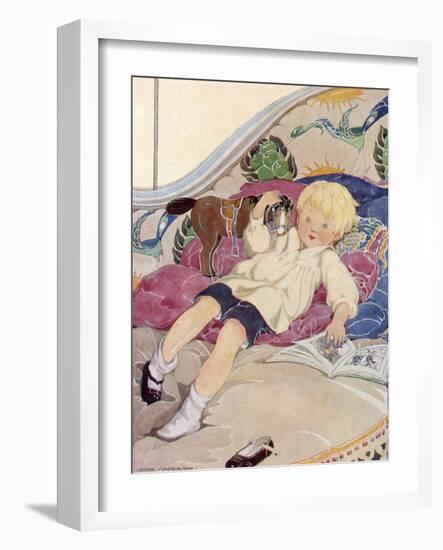 A Boy Lying on a Bed with a Book and a Toy Horse-Anne Anderson-Framed Art Print