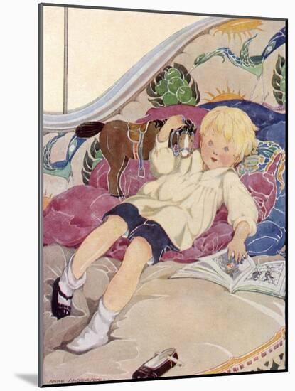 A Boy Lying on a Bed with a Book and a Toy Horse-Anne Anderson-Mounted Art Print