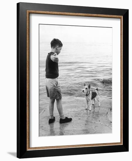 A Boy Throws Stones into the Sea for His Dog to Retrieve: the Dog Looks Up Expectantly-Henry Grant-Framed Photographic Print