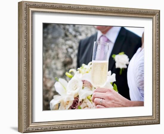 A Bride and Groom with a Glass of Champagne and a Bouquet-null-Framed Photographic Print