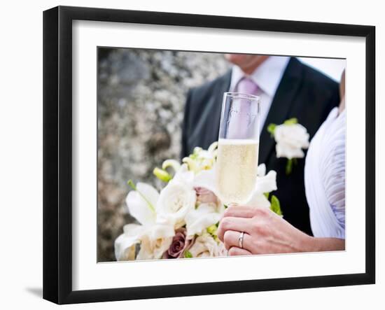 A Bride and Groom with a Glass of Champagne and a Bouquet-null-Framed Photographic Print