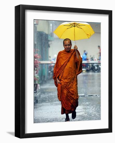 A Buddhist Monk Walks in the Rain on a Street in Bangkok-null-Framed Photographic Print