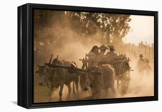 A bull cart kicks up a cloud of dust on the road to Indawgyi Lake, Kachin State, Myanmar (Burma), A-Alex Treadway-Framed Premier Image Canvas