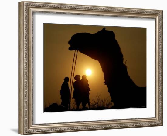 A Camel Stands as Villagers Walk at Sunrise at the Annual Cattle Fair in Pushkar, November 3, 2006-Rajesh Kumar Singh-Framed Photographic Print