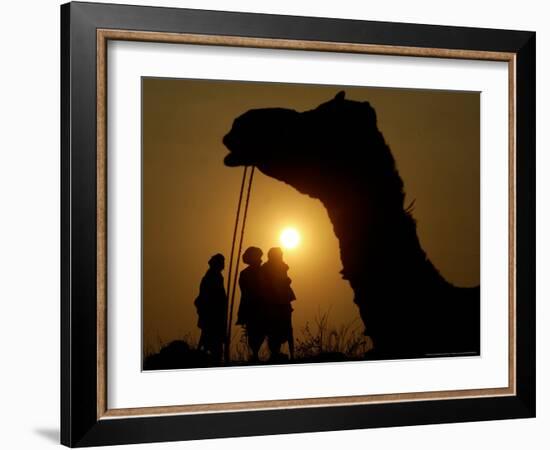 A Camel Stands as Villagers Walk at Sunrise at the Annual Cattle Fair in Pushkar, November 3, 2006-Rajesh Kumar Singh-Framed Photographic Print