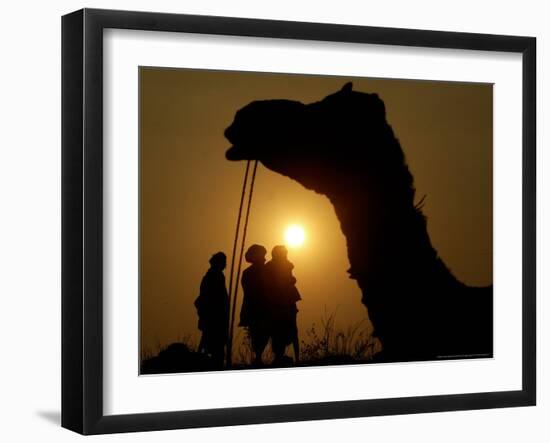 A Camel Stands as Villagers Walk at Sunrise at the Annual Cattle Fair in Pushkar, November 3, 2006-Rajesh Kumar Singh-Framed Photographic Print