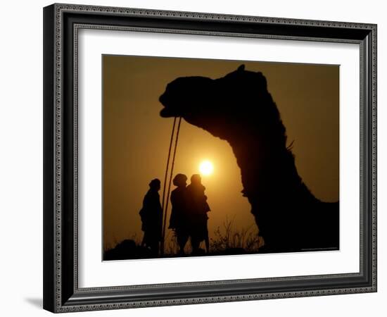 A Camel Stands as Villagers Walk at Sunrise at the Annual Cattle Fair in Pushkar, November 3, 2006-Rajesh Kumar Singh-Framed Photographic Print