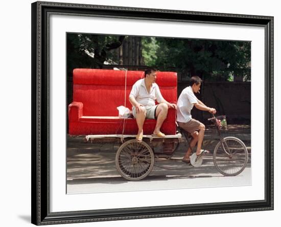 A Chinese Man Rides on a Sofa as Another Pedals a Delivery Tricycle-null-Framed Photographic Print