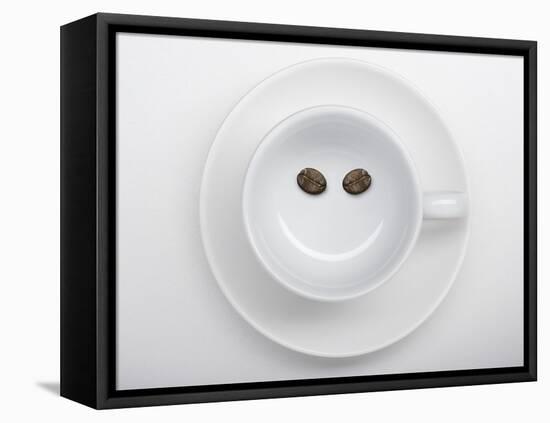 A Coffee Cup with Two Coffee Beans Making a Smiley Face-Jean Gillis-Framed Premier Image Canvas