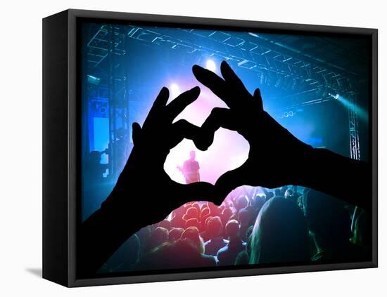 A Crowd of People at a Concert with a Heart Shaped Hand Shadow-graphicphoto-Framed Premier Image Canvas