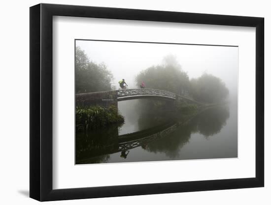 A cyclist on a bridge on Birmingham Canal Navigations (BCN), Birmingham, West Midlands, England, Un-Graham Lawrence-Framed Photographic Print