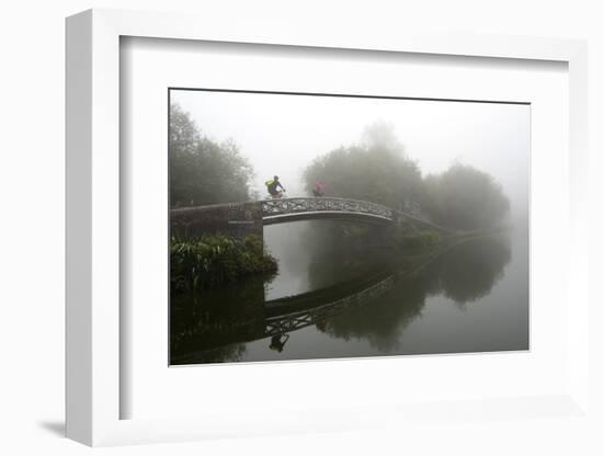 A cyclist on a bridge on Birmingham Canal Navigations (BCN), Birmingham, West Midlands, England, Un-Graham Lawrence-Framed Photographic Print