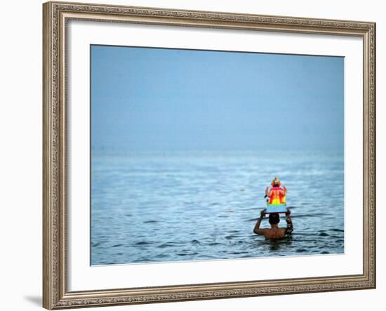 A Devotee Immerses the Idol of Elephant-Headed Hindu God Ganesh-null-Framed Photographic Print