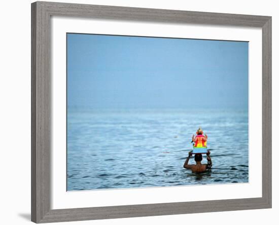 A Devotee Immerses the Idol of Elephant-Headed Hindu God Ganesh-null-Framed Photographic Print