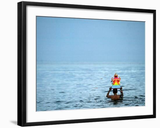 A Devotee Immerses the Idol of Elephant-Headed Hindu God Ganesh-null-Framed Photographic Print