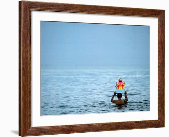 A Devotee Immerses the Idol of Elephant-Headed Hindu God Ganesh-null-Framed Photographic Print