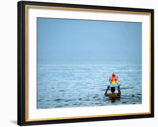 A Devotee Immerses the Idol of Elephant-Headed Hindu God Ganesh-null-Framed Photographic Print