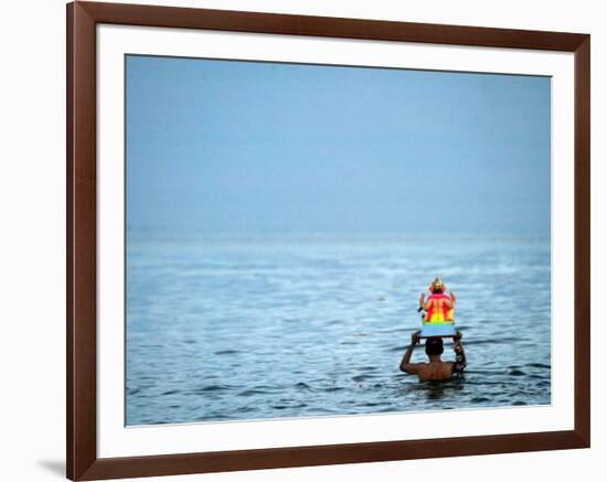 A Devotee Immerses the Idol of Elephant-Headed Hindu God Ganesh-null-Framed Photographic Print