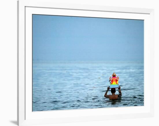 A Devotee Immerses the Idol of Elephant-Headed Hindu God Ganesh-null-Framed Photographic Print