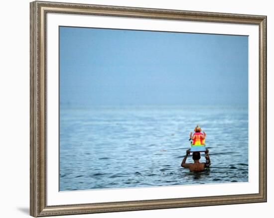 A Devotee Immerses the Idol of Elephant-Headed Hindu God Ganesh-null-Framed Photographic Print