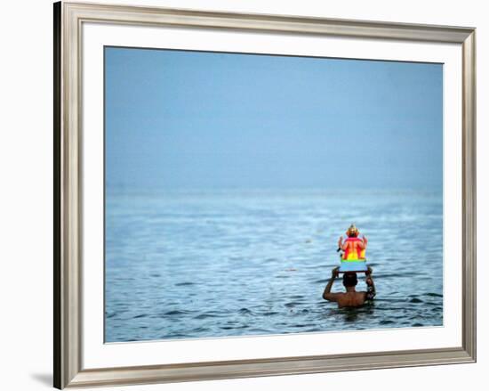 A Devotee Immerses the Idol of Elephant-Headed Hindu God Ganesh-null-Framed Photographic Print