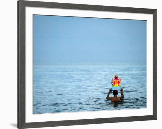 A Devotee Immerses the Idol of Elephant-Headed Hindu God Ganesh-null-Framed Photographic Print