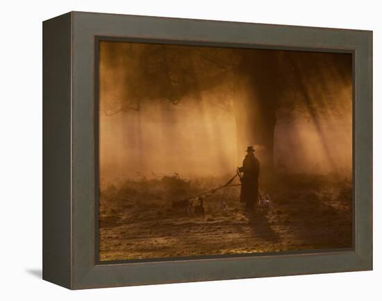 A Dog Walker Makes His Way with Four Dogs in the Early Morning Mist in Richmond Park-Alex Saberi-Framed Premier Image Canvas