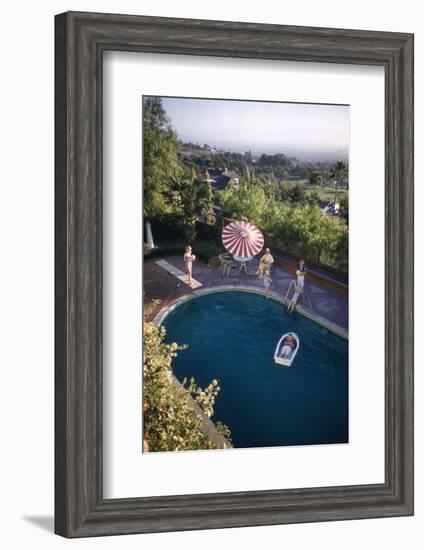 A Family at their Backyard Swimming Pool, in Foreground a Floating Rowboat with Boy Aboard-Frank Scherschel-Framed Photographic Print