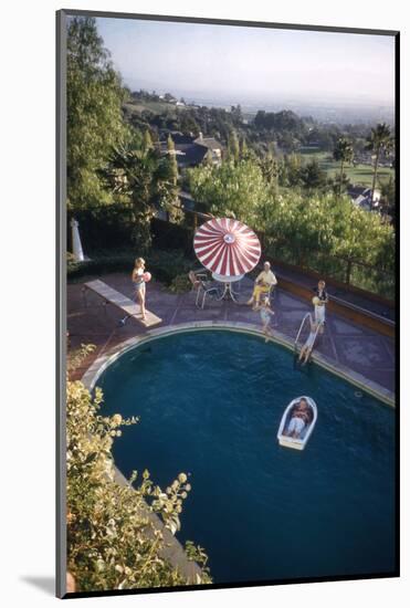 A Family at their Backyard Swimming Pool, in Foreground a Floating Rowboat with Boy Aboard-Frank Scherschel-Mounted Photographic Print