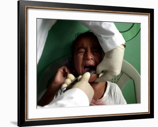 A Girl, 6, Cries as Dentist Allan Castellanos Removes a Molar Toot-null-Framed Photographic Print