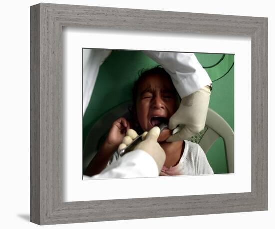 A Girl, 6, Cries as Dentist Allan Castellanos Removes a Molar Toot-null-Framed Photographic Print