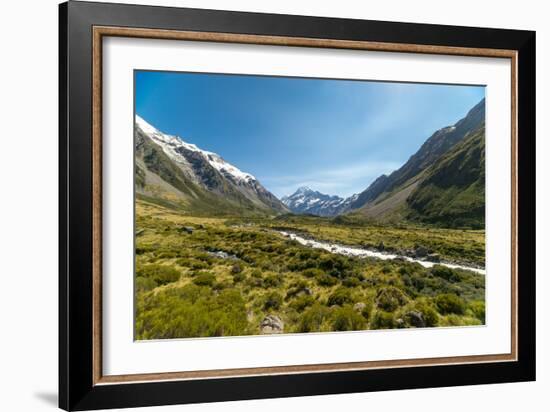 A glacier fed creek cuts through a green valley high in the mountains, South Island, New Zealand-Logan Brown-Framed Photographic Print